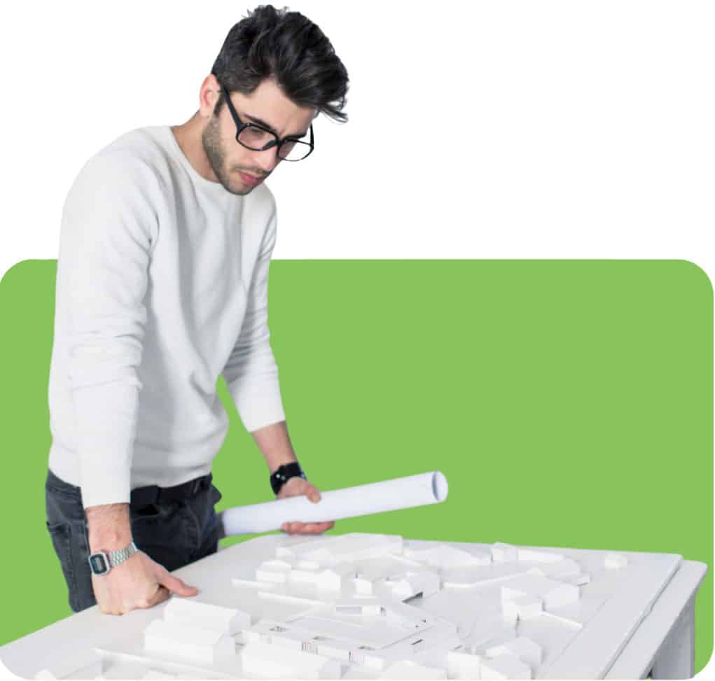 A man holding blueprints while looking down at a 3d model of a project.